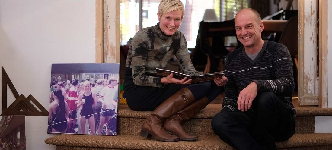 Uitvaartverzorgers Max en Michèle thuis zittend op de trap met hun laatste uitvaart wensen boek in de hand.